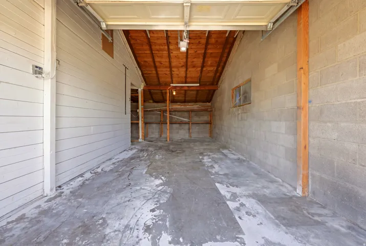 Concrete flooring, wood plank ceiling, exposed wood beams, built-in shelving, concrete block wall