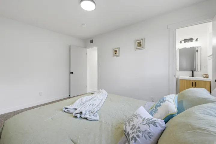 Recessed ceiling light, neutral wall paint, carpeted flooring, white trim details, and a bathroom vanity with a mirror