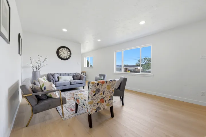 Bright living area featuring wood-finish flooring, white walls, and recessed lighting