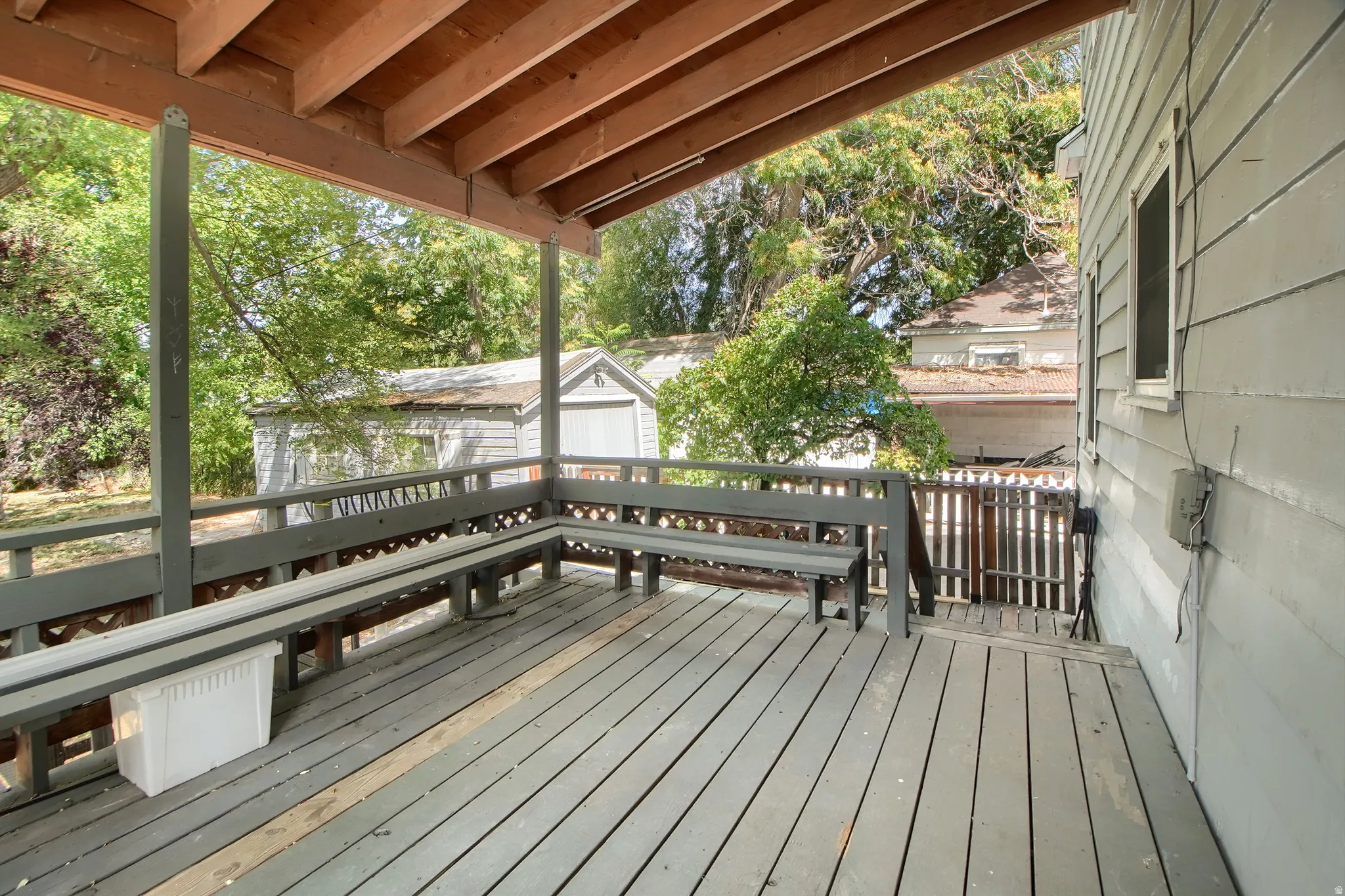 Covered porch with wood flooring and built-in benches
