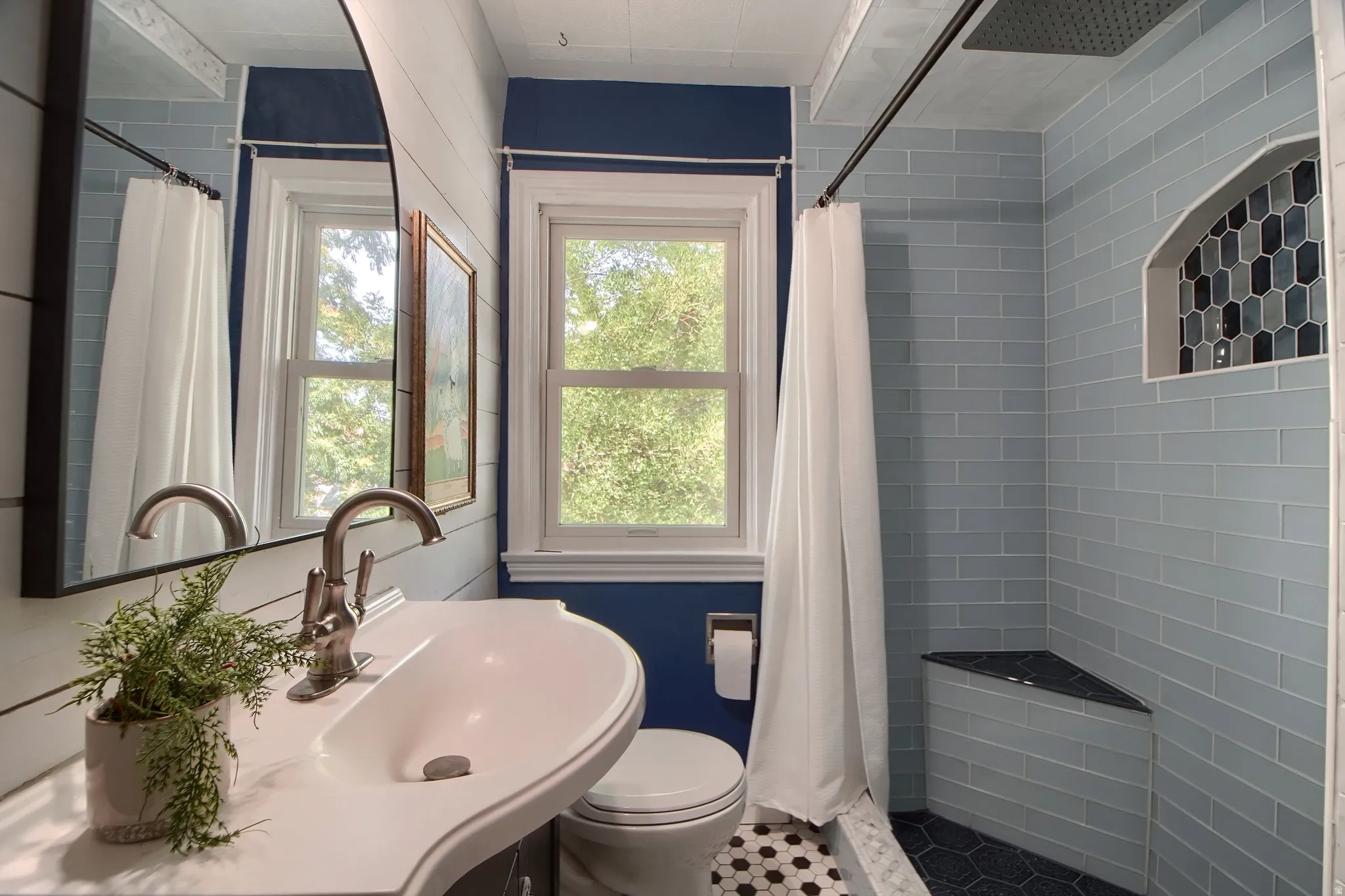 Bathroom featuring a built-in shower niche with mosaic tile, a corner shower bench, and a vanity with an integrated sink