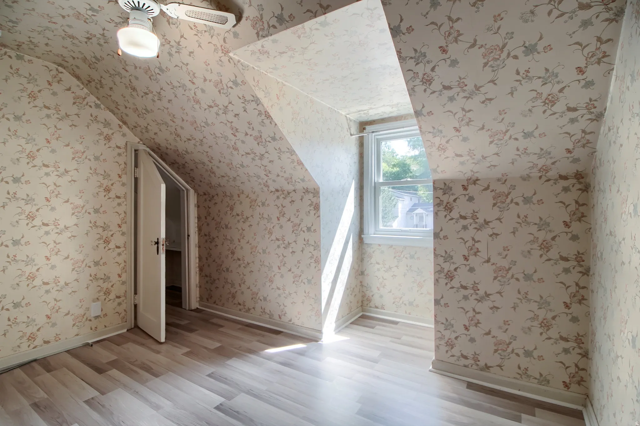 Wood-finish flooring with a side-hinged window, and an attached ceiling fan with lighting