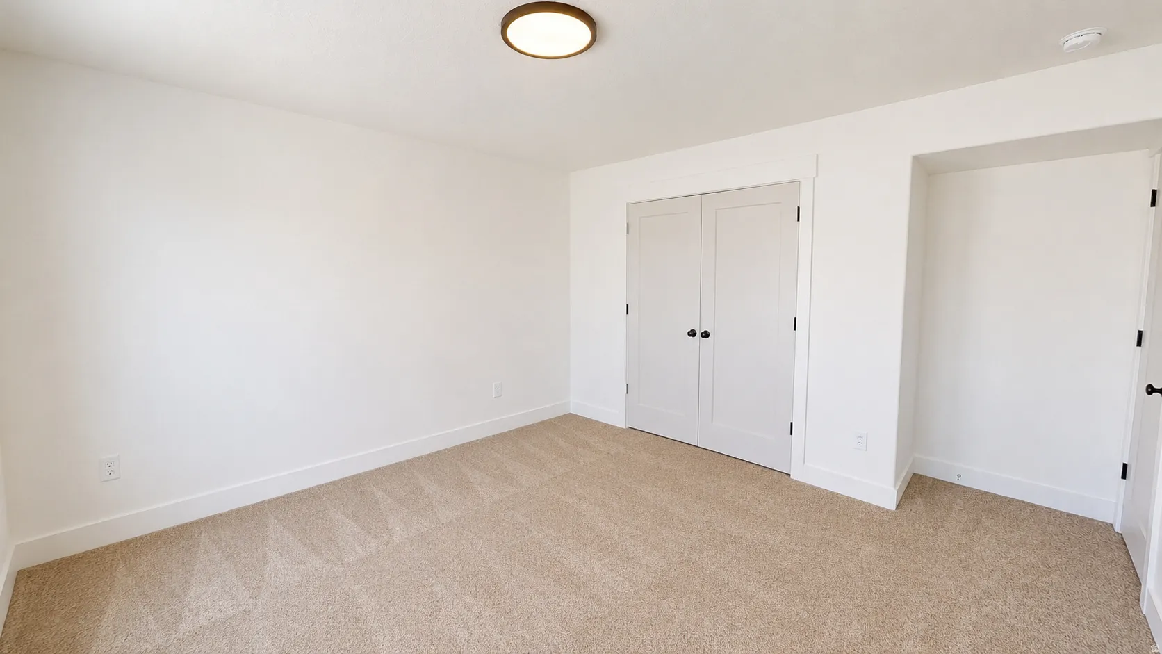 Neutral-toned carpeted flooring complements white walls and trim