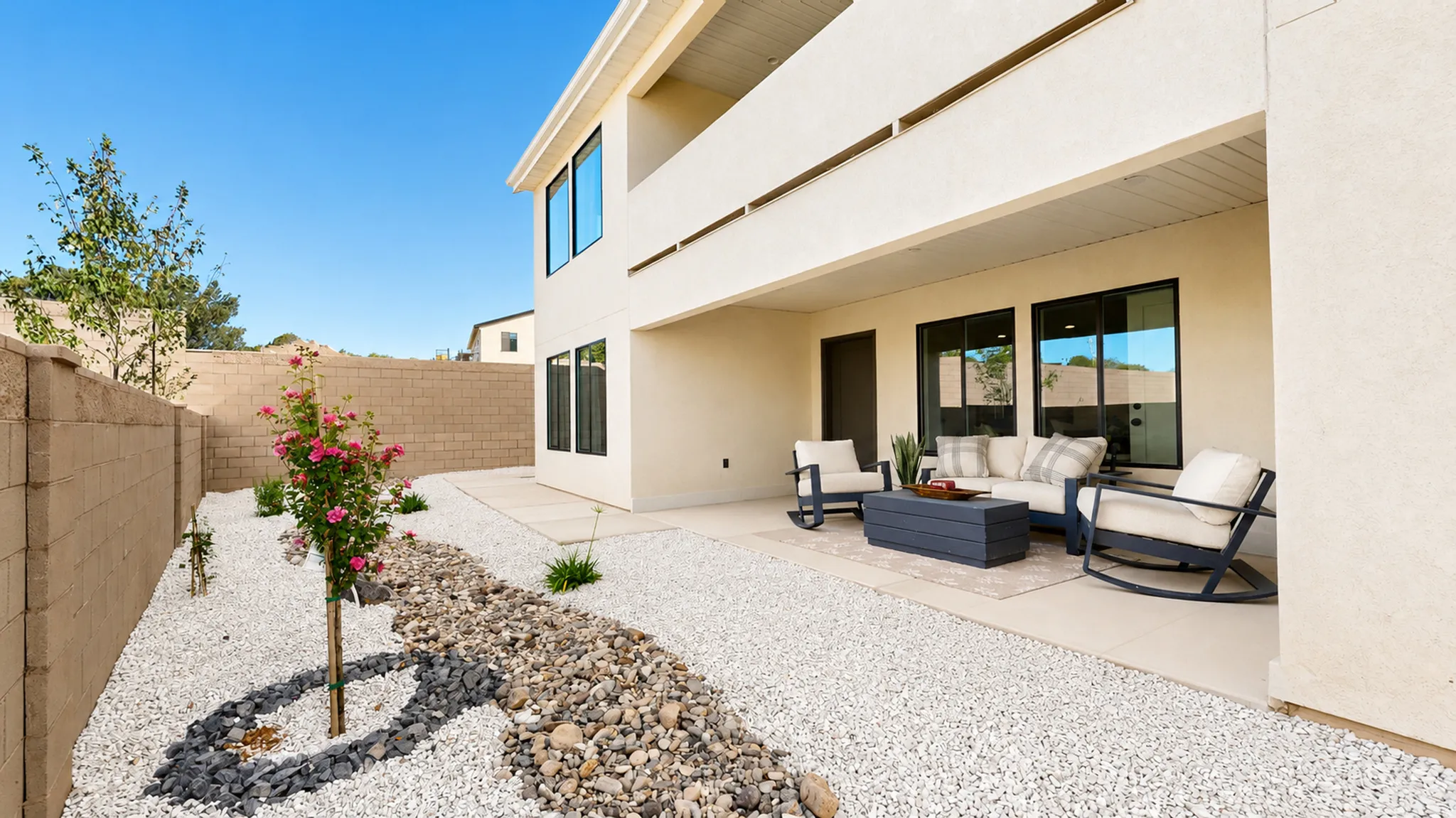 Private patio area featuring a concrete surface, a stucco exterior, and black-framed windows