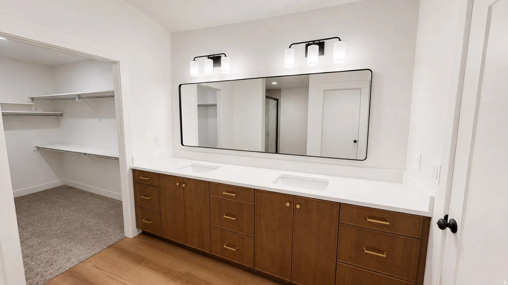 Dual vanity featuring wood-finish cabinetry, white countertops, and undermount sinks