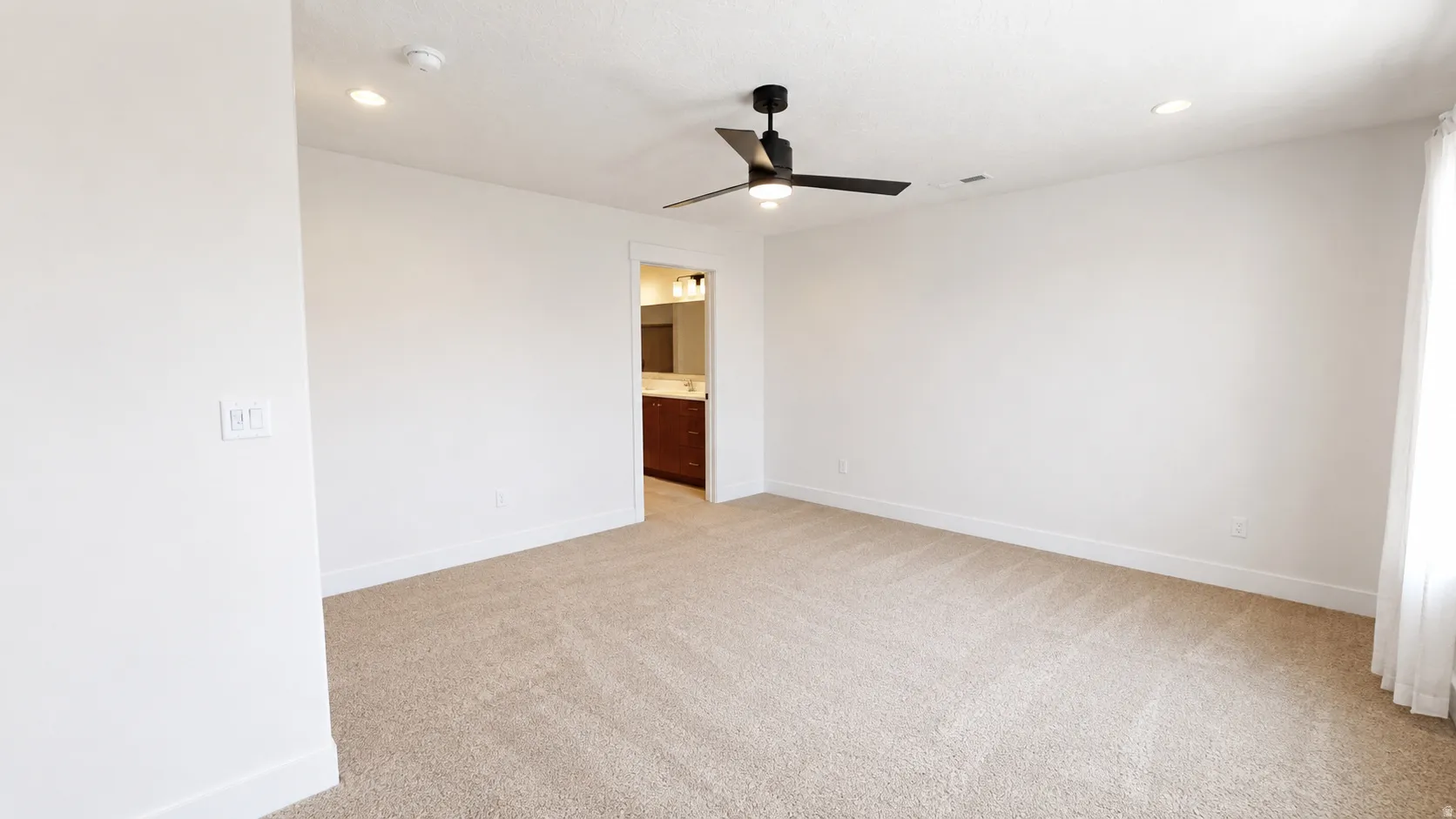 Carpeted flooring, recessed lighting, ceiling fan with light, and an open doorway