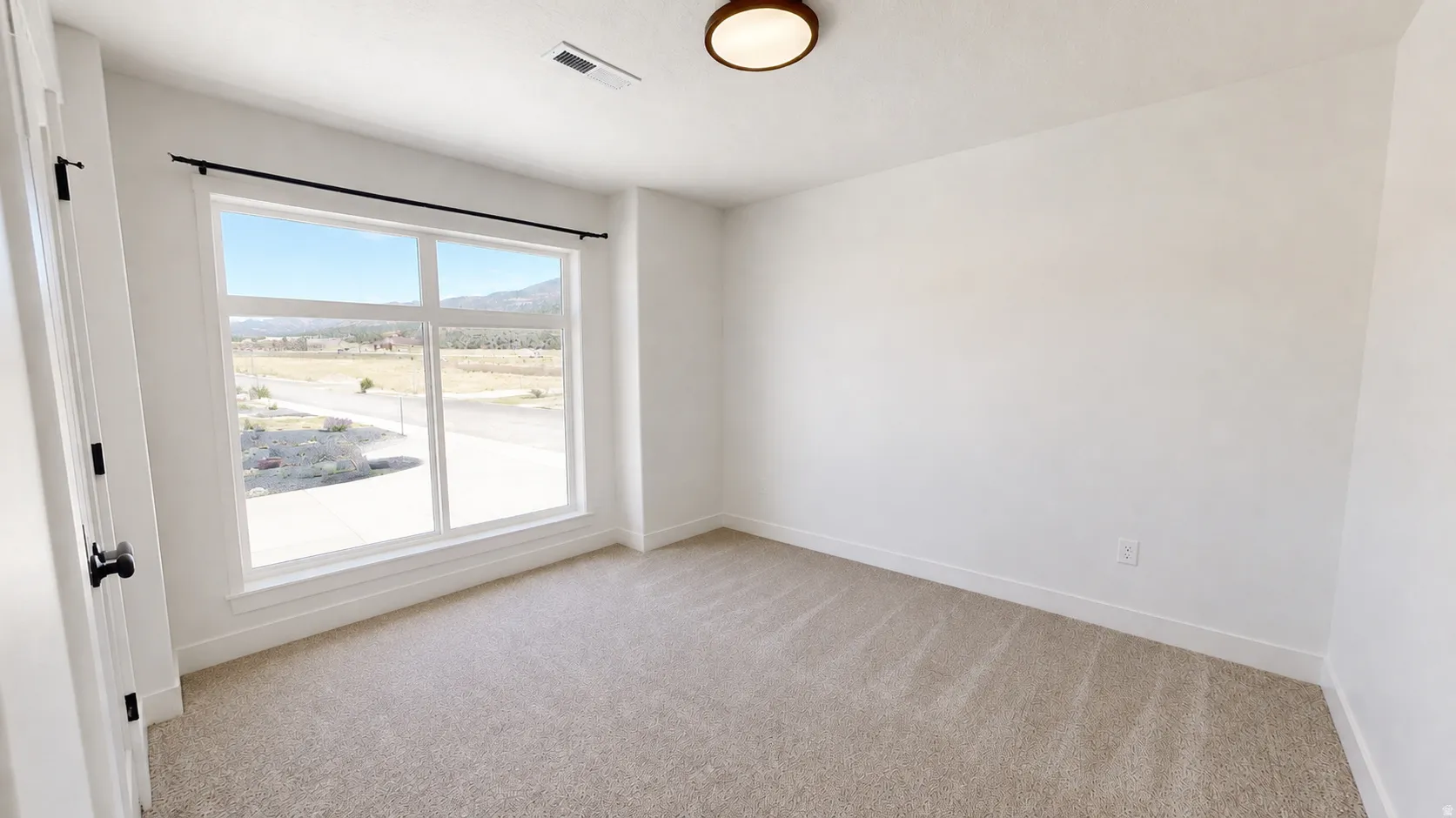 Spacious room with plush carpeting and a large window