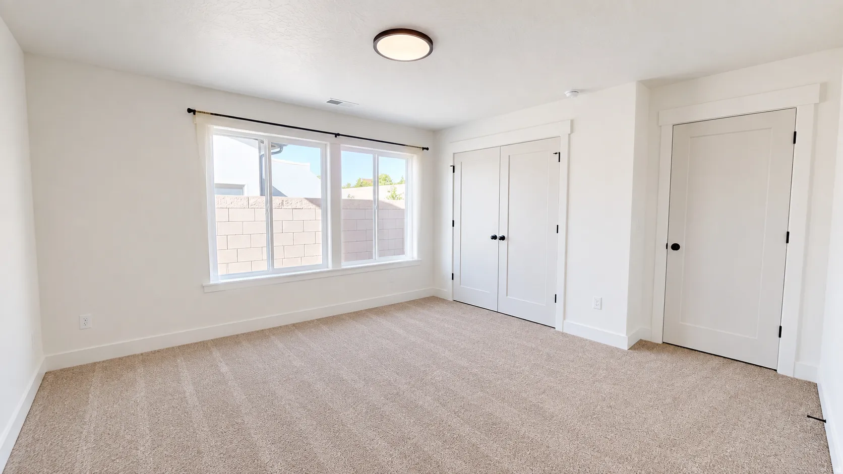 Carpeted flooring, white walls, and a contemporary flush-mount ceiling light