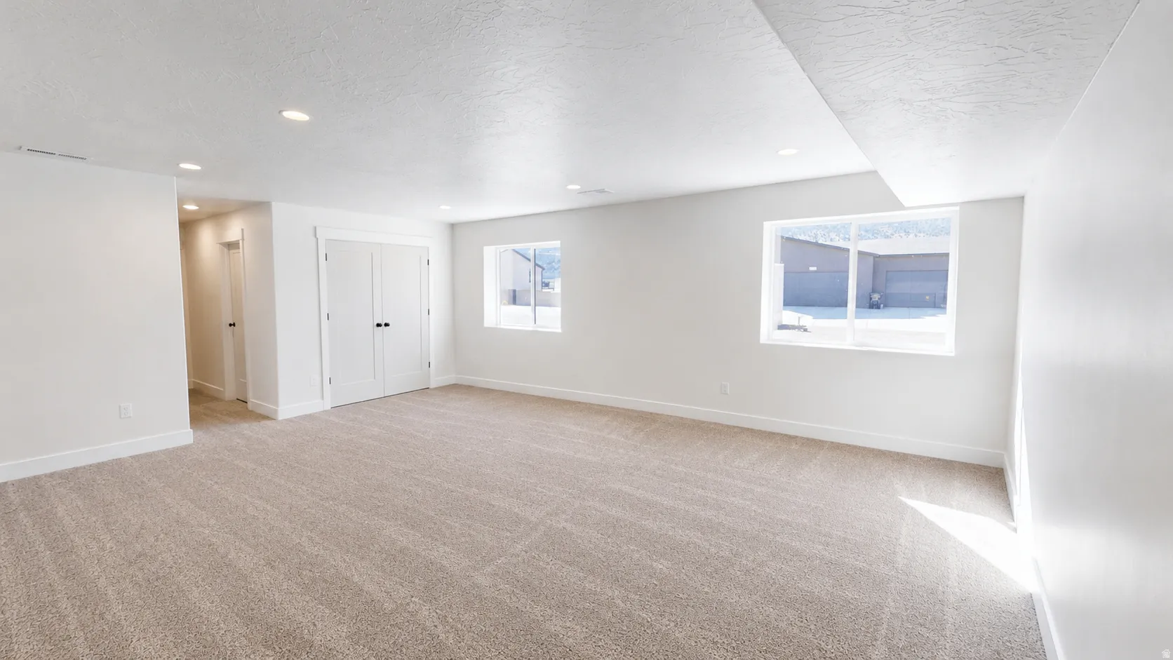 Recessed lighting, carpeted flooring, white trim, and white walls