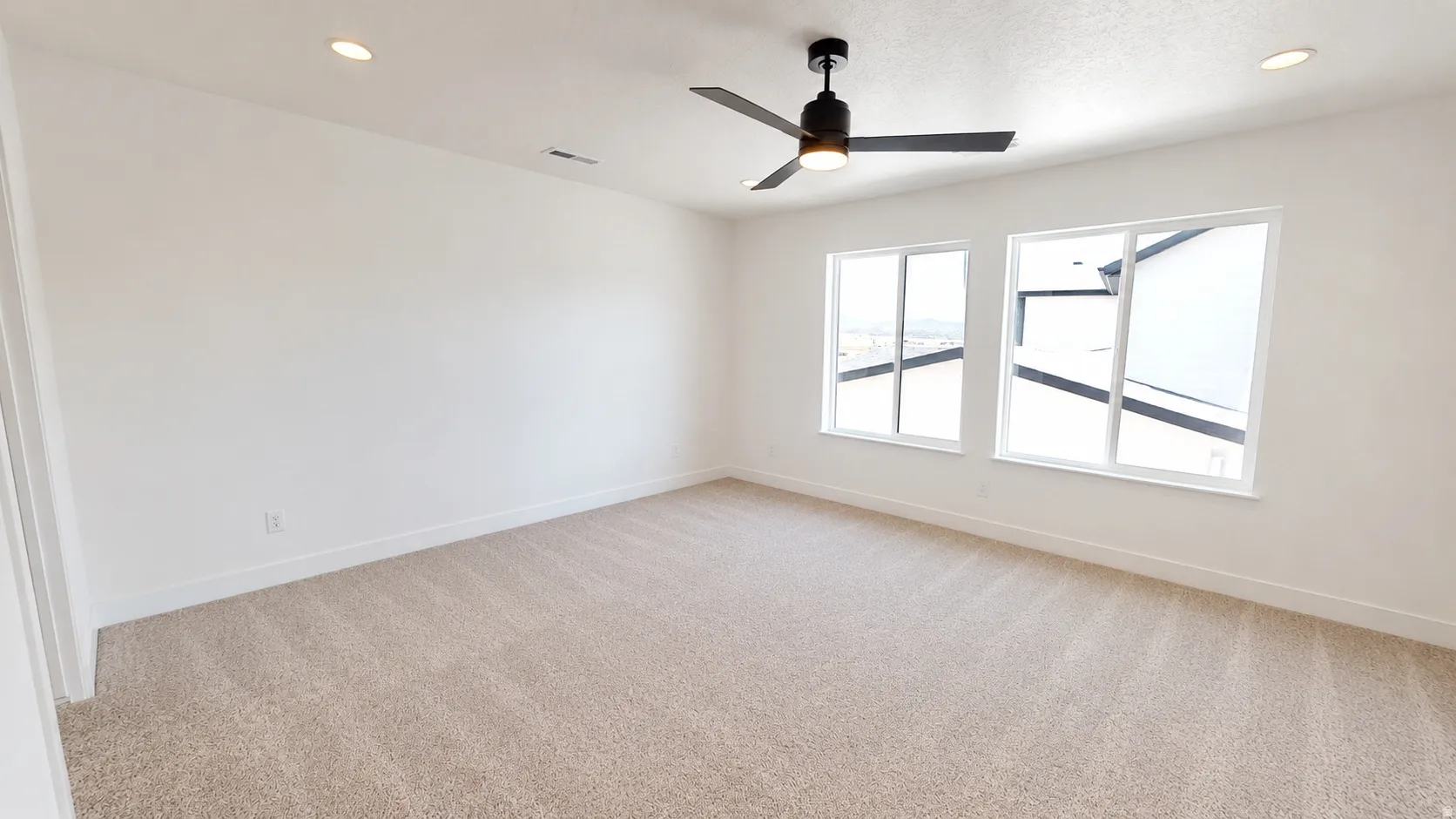 Recessed lighting, ceiling fan, two windows, and carpet flooring