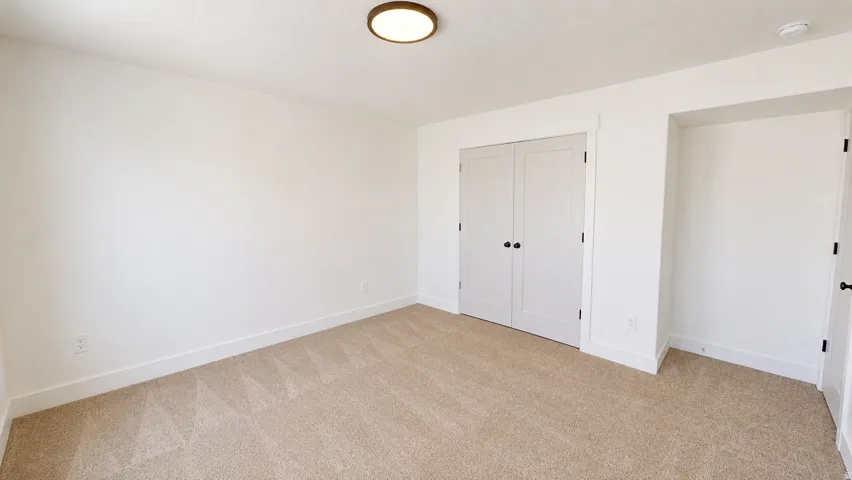 Neutral-toned carpeted flooring complements white walls and trim