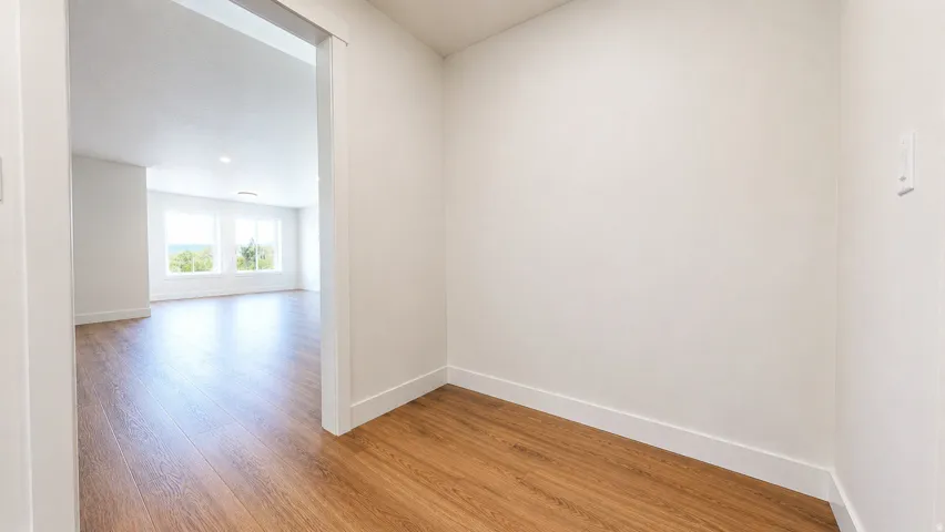 Wood-finish flooring throughout, white wall finishes, and recessed ceiling lighting