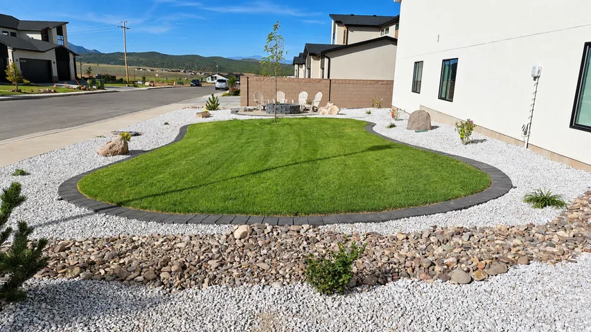 Manicured lawn with paver edging, surrounded by decorative white gravel, and a rock-lined dry creek bed
