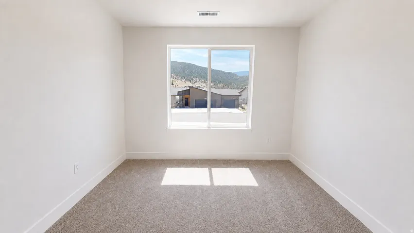 Recessed window with a mountain backdrop, neutral carpeting, and white walls