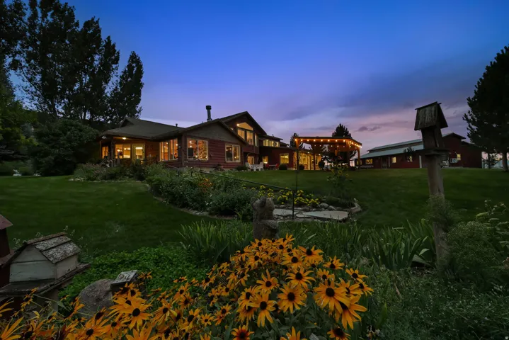 Expansive landscaped grounds featuring a variety of plantings, a large lawn, and mature trees