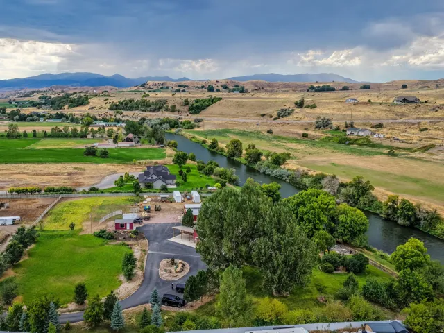 Expansive rural landscape with a river, distant mountains, and cultivated fields