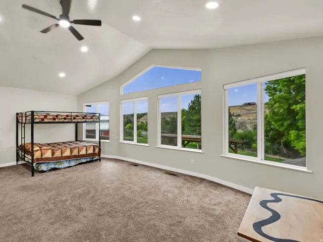 Vaulted ceiling with recessed lighting and a ceiling fan