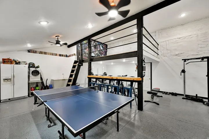 Spacious open-plan room with a finished concrete floor, recessed lighting, and ceiling fans
