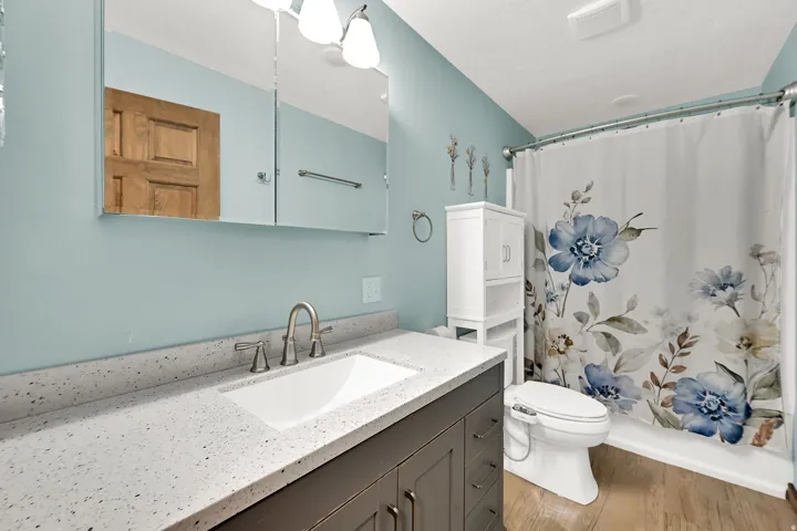 Built-in vanity with an integrated sink, brushed nickel faucet, and speckled countertop