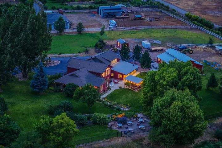 Expansive property featuring multiple structures, mature trees, and a spacious lawn