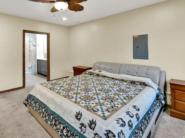 Carpeted room featuring a ceiling fan with integrated lighting, recessed lighting, and a walk-in closet with built-in shelving