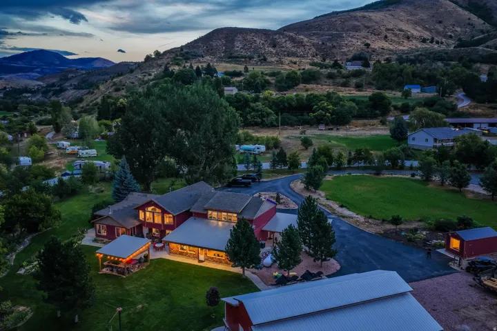 Expansive property featuring multiple structures, a paved drive, and surrounding natural landscapes