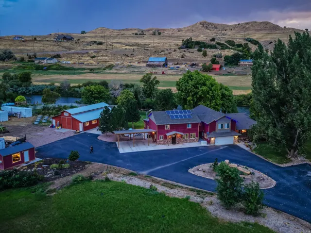 Red-hued two-story residence with attached garage, solar panels, and a covered patio