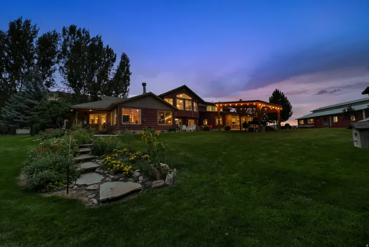 Expansive green lawn with mature trees and a stone pathway