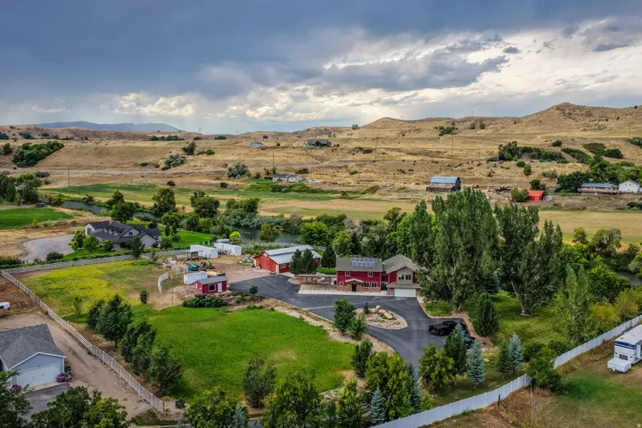 Spacious property with a large main residence, multiple outbuildings, and mature landscaping
