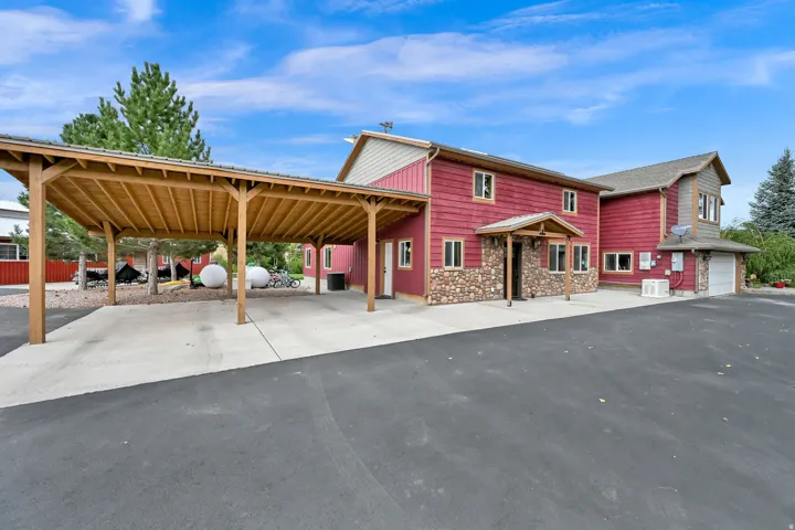 Two-story exterior with red siding and stone veneer accents