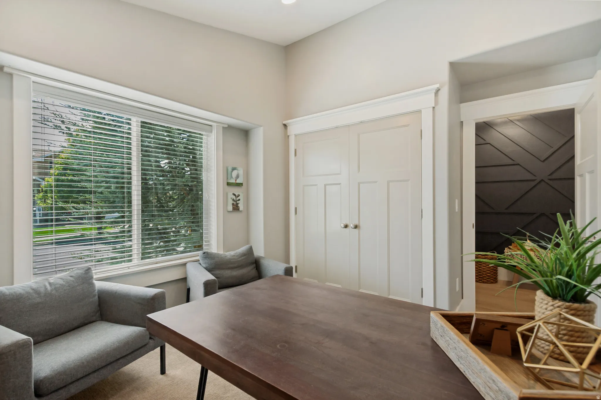 Large window with horizontal blinds, light-toned wall paint, double paneled doors, and ceiling lighting