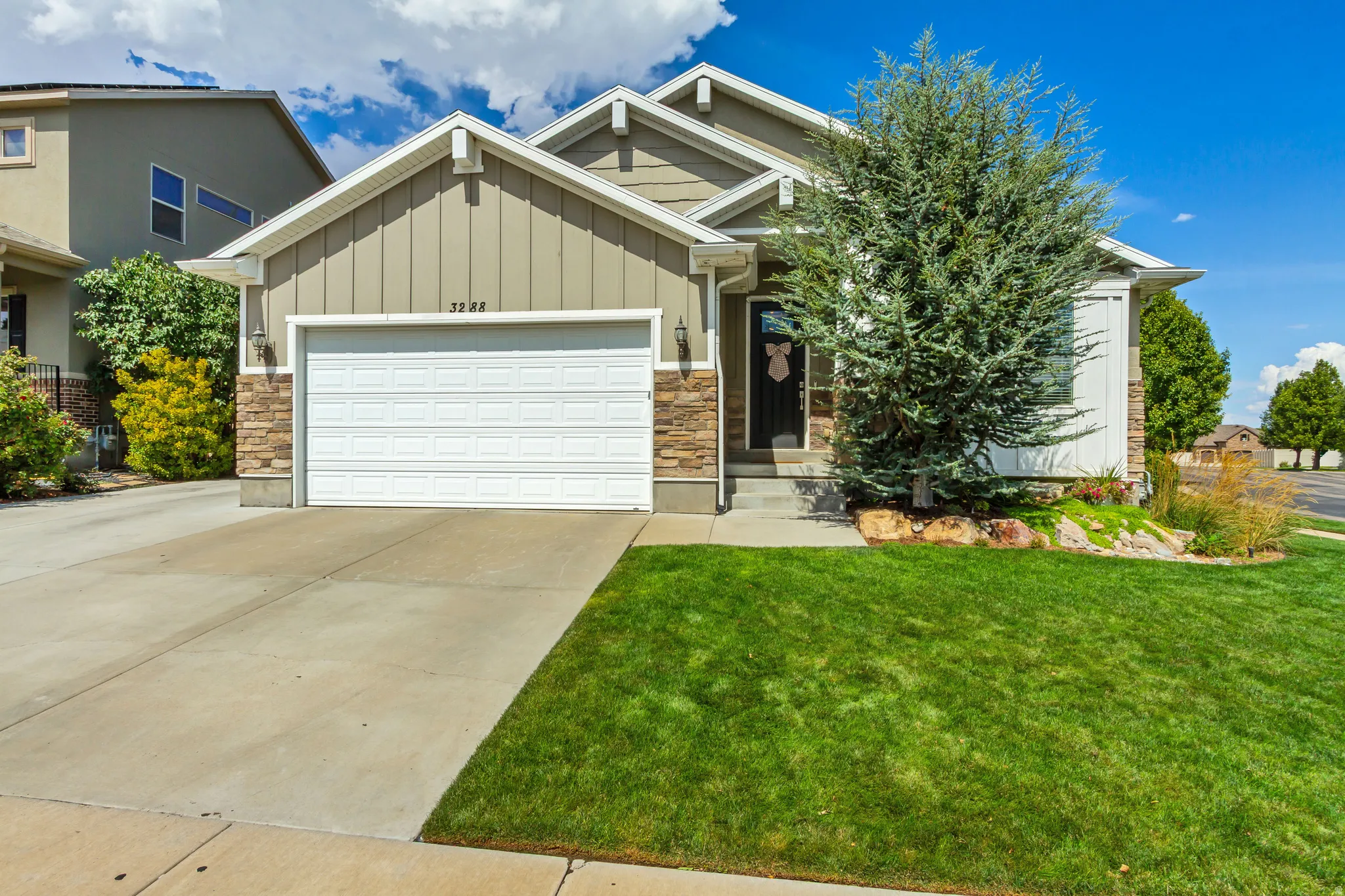 Contemporary exterior featuring stone accents, horizontal siding, and a two-car garage