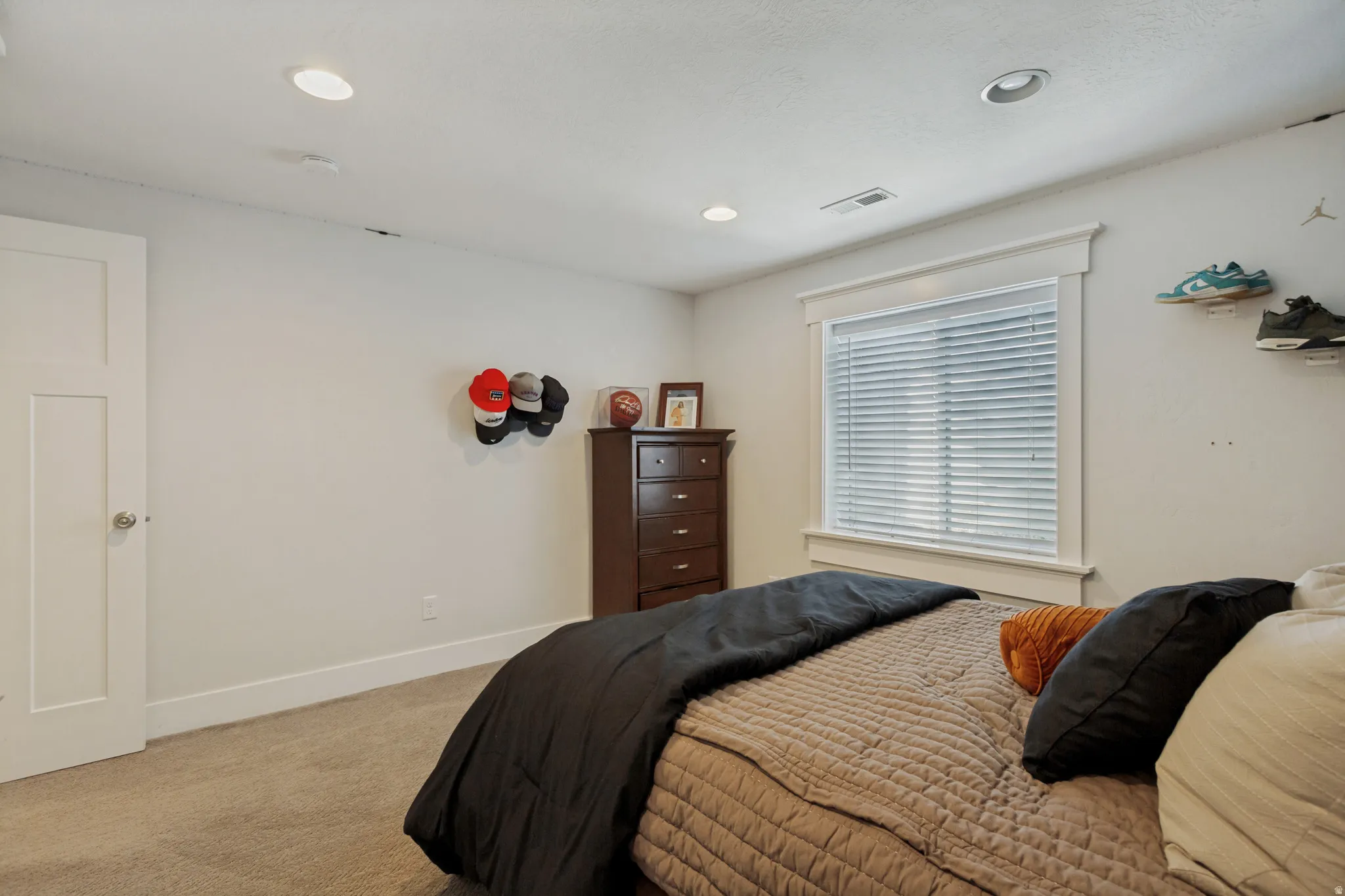 Recessed lighting, soft carpet flooring, white trim, and a white interior door