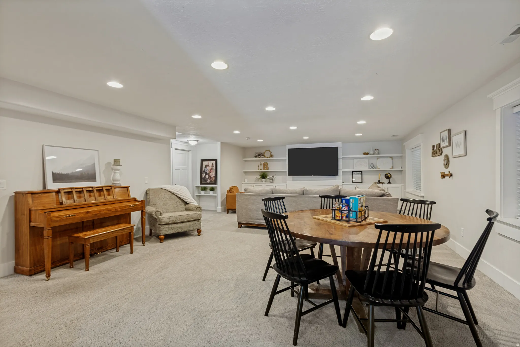 Recessed lighting, light-toned carpeting, built-in shelving, white trim, and window treatments
