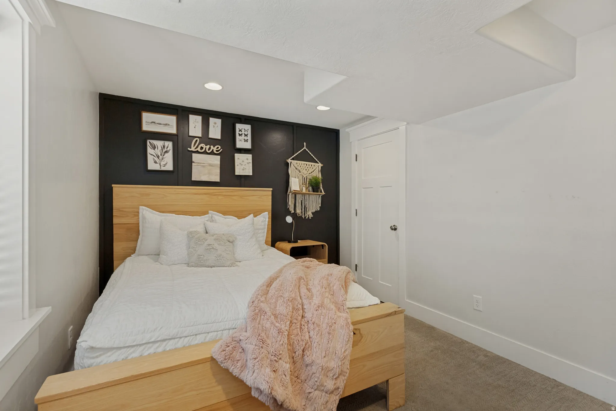 Recessed ceiling lighting, durable carpeting, white trim, and a paneled wall accent