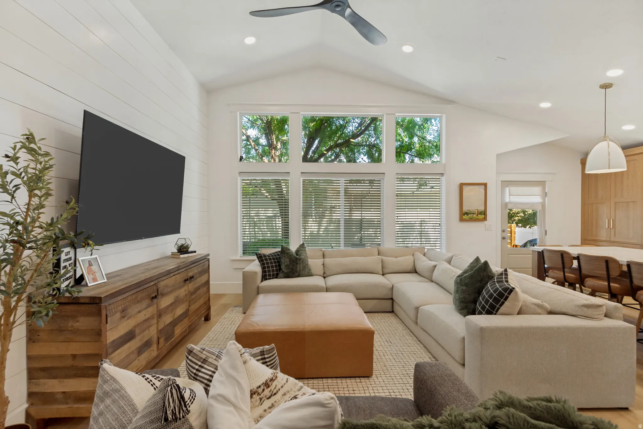 Vaulted ceiling with recessed lighting, integrated ceiling fan, and shiplap accent wall