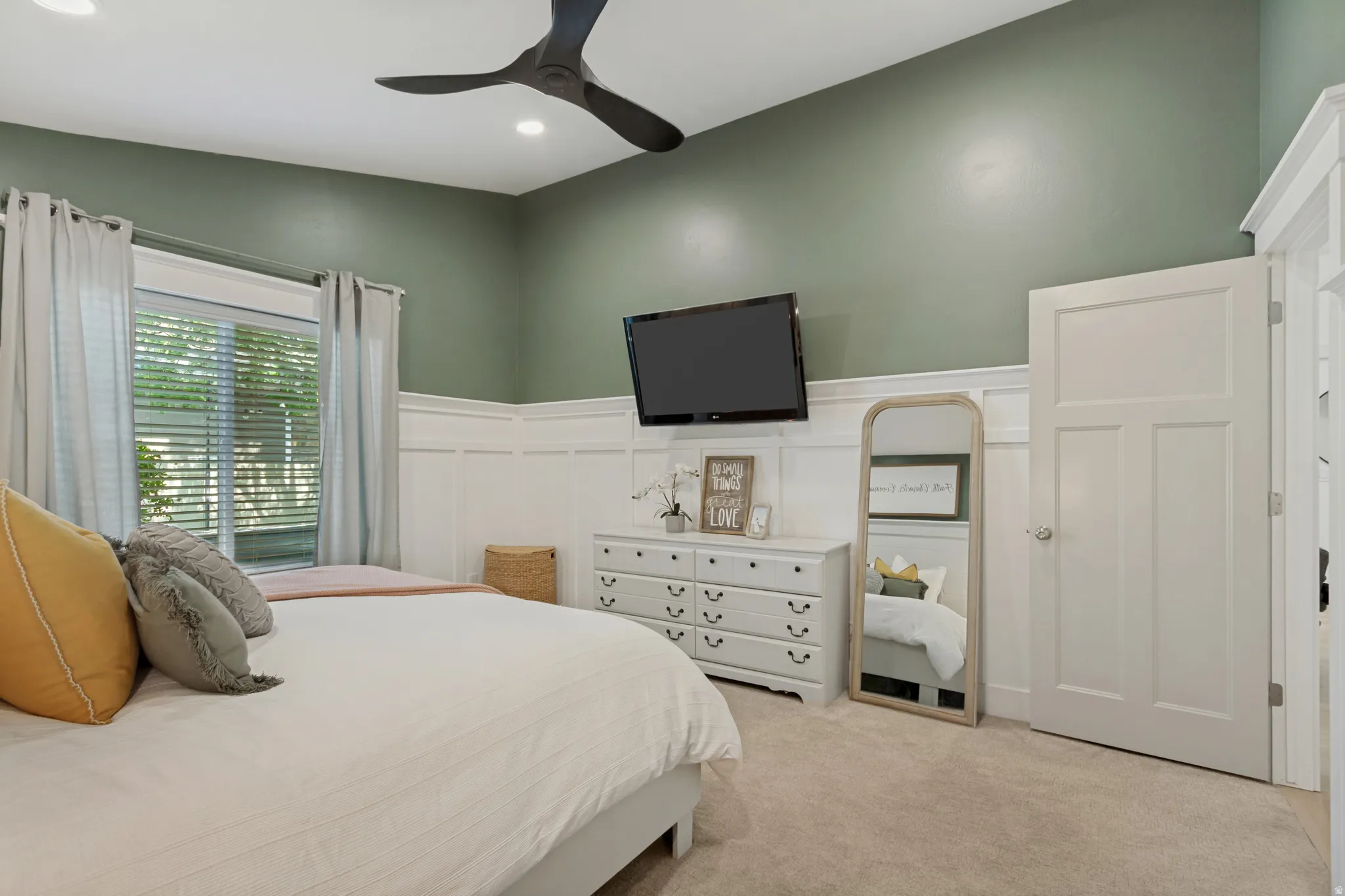 Recessed lighting, ceiling fan, board and batten wall treatment, window with blinds, and white door with paneling