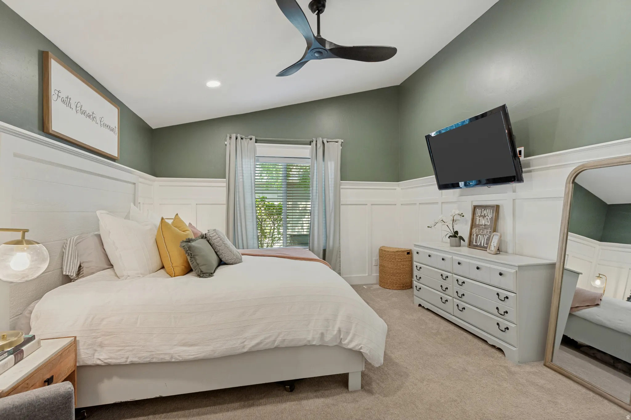Tray ceiling with recessed lighting, board and batten wall paneling, wall-mounted television, ceiling fan, and carpeted flooring