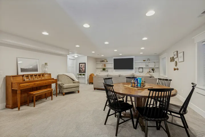 Recessed lighting, light-toned carpeting, built-in shelving, white trim, and window treatments