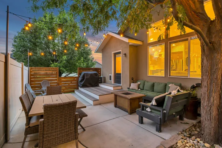 Concrete patio with a wood-finish tiered deck, wood slat fencing, and privacy fencing