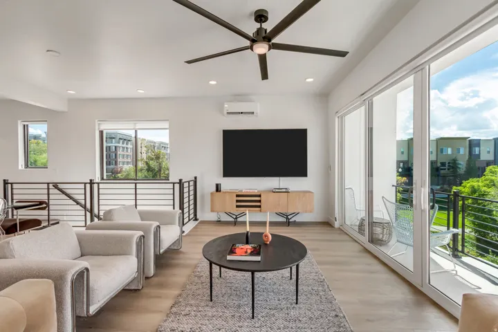 Recessed lighting, wood-finish flooring, a contemporary ceiling fan, and a built-in wall unit