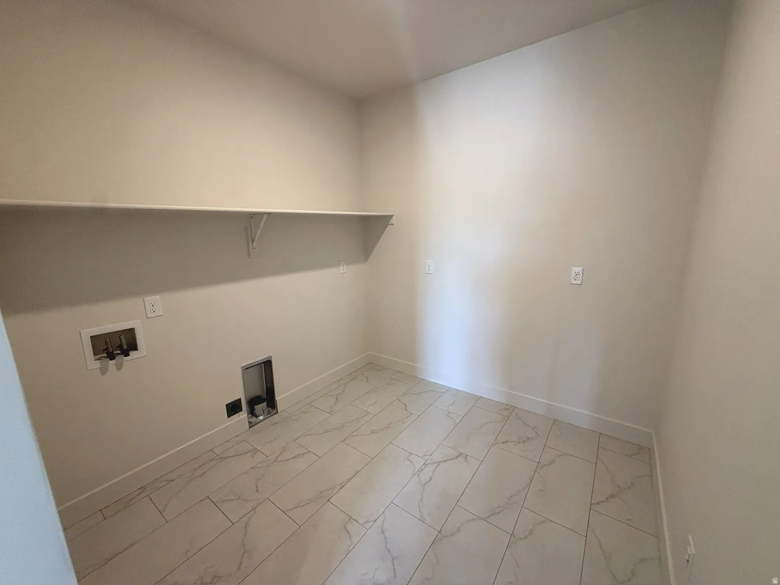 White tile flooring with a marble-effect pattern, light-toned wall paint, and a built-in white shelf