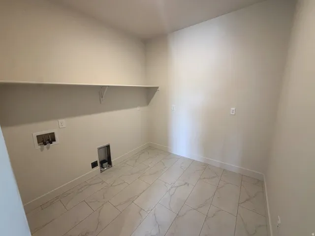 White tile flooring with a marble-effect pattern, light-toned wall paint, and a built-in white shelf