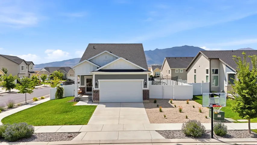 Contemporary exterior with a covered entry, attached garage, and a fenced yard featuring a gravel landscape