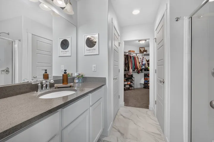 Bathroom featuring a single vanity with a stone countertop, an undermount sink, and polished chrome fixtures