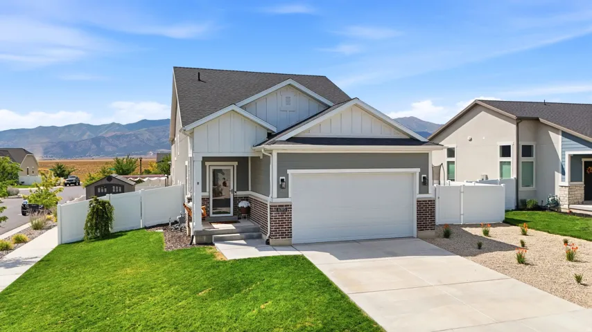 Contemporary exterior with a two-car garage, partial brick facade, and a covered entry
