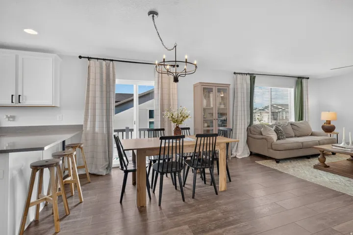 Open-concept living space featuring wood-finish flooring, white cabinetry, and a sliding glass door