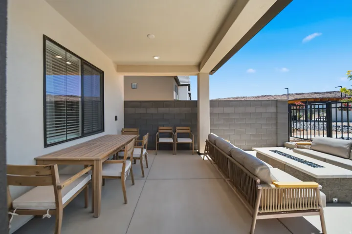 Covered patio featuring a concrete slab, recessed lighting, and a stone-built fire pit