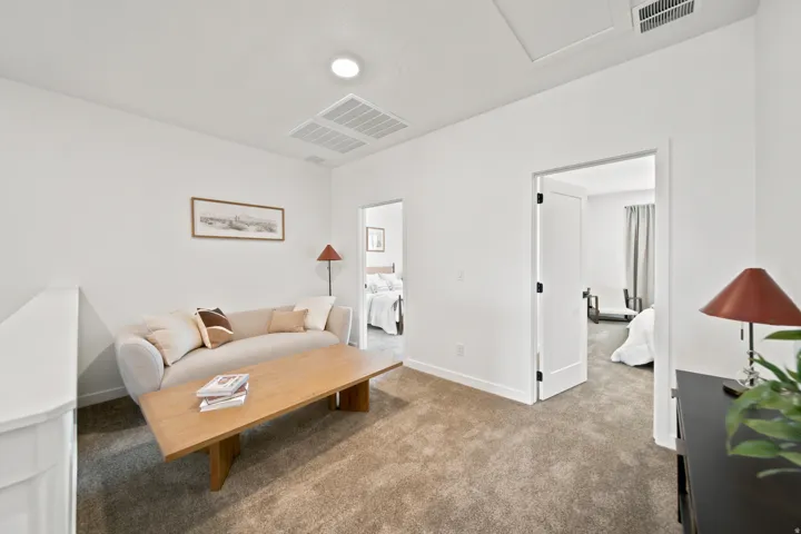 Carpeted landing area featuring white walls, recessed lighting, and a white railing