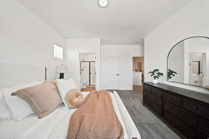 White walls with recessed lighting, carpet flooring, a white door with black hardware, and a separate room with wood-finish flooring